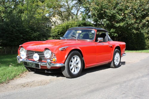 1965 TR4A IRS SIGNAL RED WITH OVERDRIVE AND SURREY TOP. SOLD